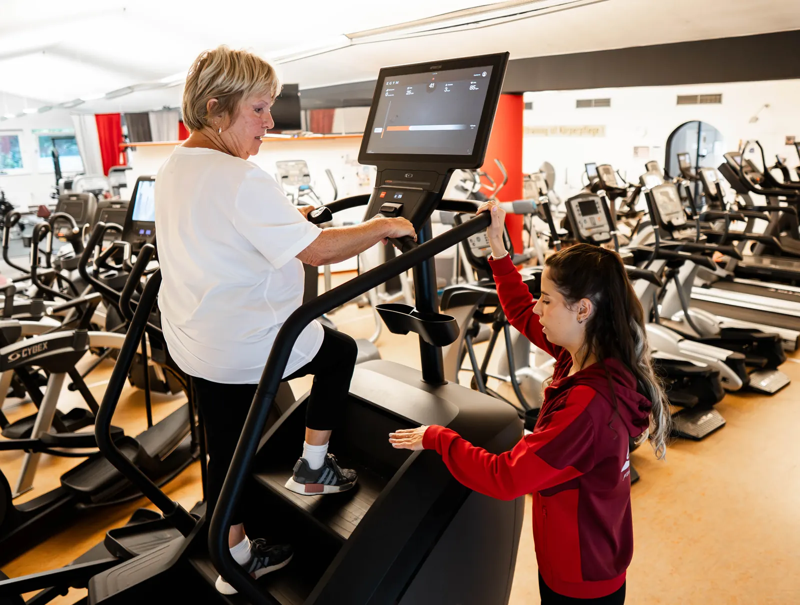Therapeutin begleitet Training auf dem Cardiogerät